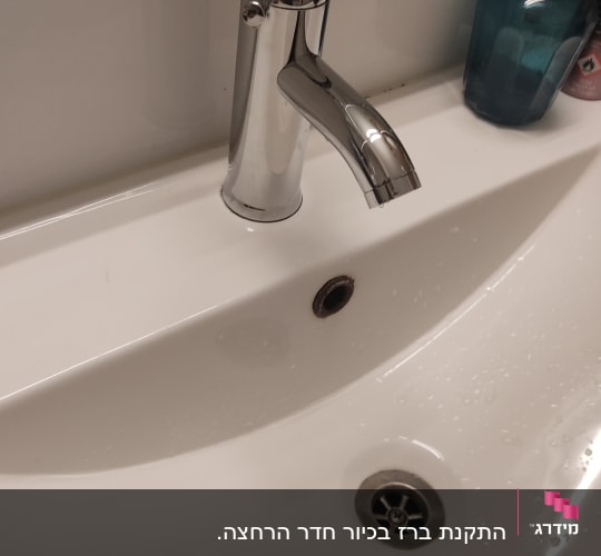 ברז כרום מעל כיור לבן עם ניקוז